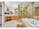 This light and bright bathroom features a sunken tub, glass shower, and vanity at 8925 Rio Verde Ave, Las Vegas, NV 89147