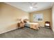 Cozy bedroom with neutral walls, plush carpet, ceiling fan, and a sunny window with white shutters at 8925 Rio Verde Ave, Las Vegas, NV 89147