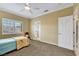 This bright bedroom features a ceiling fan, neutral walls, plush carpet, and a sunny window with white shutters at 8925 Rio Verde Ave, Las Vegas, NV 89147