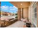 Inviting front porch featuring stone columns, tiled flooring, and a seating area at 8925 Rio Verde Ave, Las Vegas, NV 89147