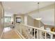 Bright hallway featuring light wood floors, white railings, and an elegant hanging light fixture at 8925 Rio Verde Ave, Las Vegas, NV 89147