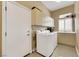 Functional laundry room with washer, dryer, utility sink, and ample storage space at 8925 Rio Verde Ave, Las Vegas, NV 89147