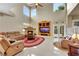 Spacious living room featuring a fireplace, high ceilings, and access to the backyard at 8925 Rio Verde Ave, Las Vegas, NV 89147