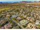 Aerial view of a residential community with mature landscaping, mountain views, and a golf course at 9616 Grand Isle Ln, Las Vegas, NV 89144