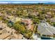 Expansive aerial view of a desert community featuring tile roof homes, lush landscaping, and mountain views at 9616 Grand Isle Ln, Las Vegas, NV 89144