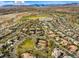 Wide aerial view of a community with golf course and mountain views featuring a park with tennis courts at 9616 Grand Isle Ln, Las Vegas, NV 89144