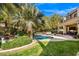 Lush backyard oasis with a sparkling pool, spa, mature trees, and inviting patio at 9616 Grand Isle Ln, Las Vegas, NV 89144