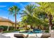 Beautiful backyard featuring pool, spa, lush landscaping, mature trees, and lounge seating at 9616 Grand Isle Ln, Las Vegas, NV 89144