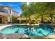 Beautiful backyard featuring a sparkling pool, spa, mature trees, and landscaping at 9616 Grand Isle Ln, Las Vegas, NV 89144