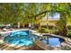 Inviting backyard oasis featuring a refreshing pool and lush tropical landscaping at 9616 Grand Isle Ln, Las Vegas, NV 89144