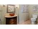 This half bath features decorative walls and wall art, a decorative mirror, and a vessel sink at 9616 Grand Isle Ln, Las Vegas, NV 89144