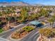 View of a gated community entrance featuring manicured landscaping and an American flag at 9616 Grand Isle Ln, Las Vegas, NV 89144