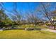 A well-maintained community park featuring green grass, mature trees, and walking path at 9616 Grand Isle Ln, Las Vegas, NV 89144
