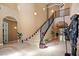 Spacious foyer with high ceilings, grand staircase, tile floors, and decorative knight armor at 9616 Grand Isle Ln, Las Vegas, NV 89144