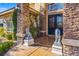 Detailed front entrance with stone accents, decorative lion statues, and lush greenery at 9616 Grand Isle Ln, Las Vegas, NV 89144