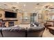 Cozy living room with a stone fireplace, spiral staircase, and comfortable seating at 9616 Grand Isle Ln, Las Vegas, NV 89144