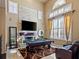 Bright living room featuring a stone fireplace, large windows, pool table, and comfortable seating at 9616 Grand Isle Ln, Las Vegas, NV 89144