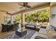 Covered patio with comfortable seating, dining area, and views of the landscaped backyard and pool at 9616 Grand Isle Ln, Las Vegas, NV 89144