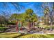 A community playground with swings and climbing structure surrounded by a well maintained park at 9616 Grand Isle Ln, Las Vegas, NV 89144