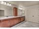 Bathroom featuring double sinks with granite counters and wood cabinets at 9781 Arcadian Estate Ct, Las Vegas, NV 89141