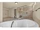 Bright bathroom features a frameless glass shower, soaking tub, and neutral tile at 9781 Arcadian Estate Ct, Las Vegas, NV 89141
