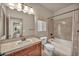 Bright bathroom featuring a single sink vanity, toilet and bathtub with tile surround at 9781 Arcadian Estate Ct, Las Vegas, NV 89141