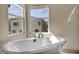 Elegant soaking tub with a modern faucet and natural light at 9781 Arcadian Estate Ct, Las Vegas, NV 89141