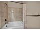 Close up of a white bathtub with bronze fixtures and decorative tan tile surround at 9781 Arcadian Estate Ct, Las Vegas, NV 89141