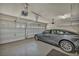 Clean and organized garage featuring epoxy floors, overhead storage, and car at 9781 Arcadian Estate Ct, Las Vegas, NV 89141