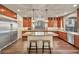 A well-lit kitchen with a large island with stool seating, wooden cabinets, and stainless steel appliances at 9781 Arcadian Estate Ct, Las Vegas, NV 89141