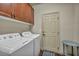 Functional laundry room with modern washer and dryer, cabinets, and a side table at 9781 Arcadian Estate Ct, Las Vegas, NV 89141