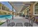 Relaxing covered patio with modern furniture and a beautiful view of the sparkling pool at 9781 Arcadian Estate Ct, Las Vegas, NV 89141