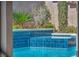 Stunning blue tiled pool and spa featuring beautiful landscaping for privacy and relaxation at 9781 Arcadian Estate Ct, Las Vegas, NV 89141