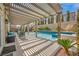 Backyard pool with a pergola, lush landscaping, a tiled water feature, and an outdoor living space at 9781 Arcadian Estate Ct, Las Vegas, NV 89141