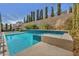 Sparkling pool with a spa and a tiled water feature is surrounded by a lush, private yard at 9781 Arcadian Estate Ct, Las Vegas, NV 89141