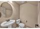 Neutral powder room features a pedestal sink and decorative mirror at 9781 Arcadian Estate Ct, Las Vegas, NV 89141