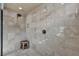 Modern walk-in shower with stone tile, a bench, and an elegant shower head at 9781 Arcadian Estate Ct, Las Vegas, NV 89141