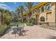 Backyard brick patio with seating area near lush landscaping and outdoor pool at 9909 Moon Valley Pl, Las Vegas, NV 89134