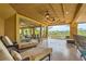 Spacious covered balcony with tile flooring, ceiling fans, lounge chairs, and a golf course view at 9909 Moon Valley Pl, Las Vegas, NV 89134