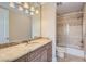 Bathroom with marble countertop, shower over tub, and decorative light fixture at 9909 Moon Valley Pl, Las Vegas, NV 89134