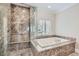 Spa-like bathroom featuring walk-in shower, soaking tub, and elegant marble finishes at 9909 Moon Valley Pl, Las Vegas, NV 89134