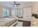 Bedroom with a bed, hardwood floors, ceiling fan and two windows with a window bench at 9909 Moon Valley Pl, Las Vegas, NV 89134