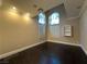 Bright bedroom with dark hardwood flooring, arched windows, and white shutters at 9909 Moon Valley Pl, Las Vegas, NV 89134