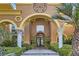 Close up of home entrance with stone steps, pillars, and wrought iron door at 9909 Moon Valley Pl, Las Vegas, NV 89134