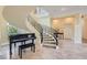 Grand foyer featuring a curved staircase with iron railings and a black piano at 9909 Moon Valley Pl, Las Vegas, NV 89134