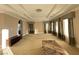Spacious living room with coffered ceilings, plush carpet, and large windows dressed with elegant draperies at 9909 Moon Valley Pl, Las Vegas, NV 89134