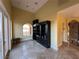 Bright living room featuring travertine floors, a built-in bookcase, and an elevator at 9909 Moon Valley Pl, Las Vegas, NV 89134