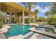 Luxury pool with a sunning shelf, palm trees, and view of the home at 9909 Moon Valley Pl, Las Vegas, NV 89134