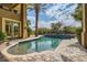 Backyard featuring a swimming pool, spa, outdoor lounge area, and palm trees at 9909 Moon Valley Pl, Las Vegas, NV 89134