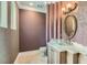 Chic powder room featuring designer wallpaper, a vessel sink, and marble countertop at 9909 Moon Valley Pl, Las Vegas, NV 89134